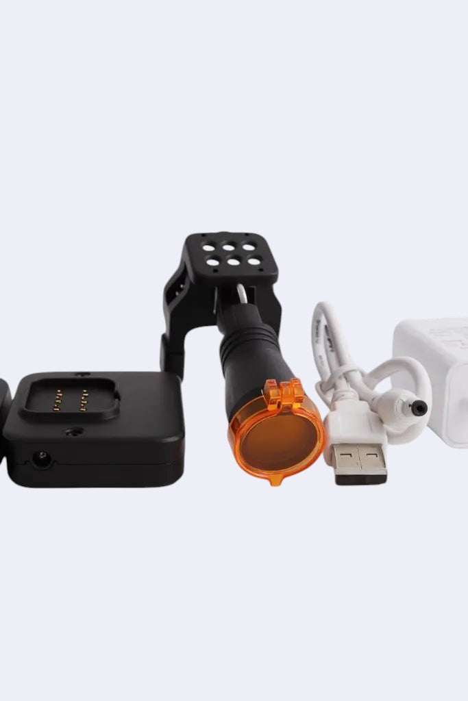 DENTISTOOLBOX black rechargeable headlamp with removable battery, orange lens, USB cable, and charger.
